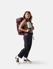 woman wearing a garnet backpack with white speed stash on white background