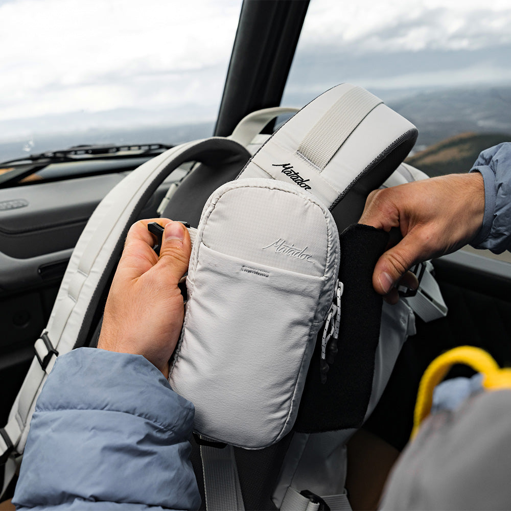 person with white backpack and speed stash in car