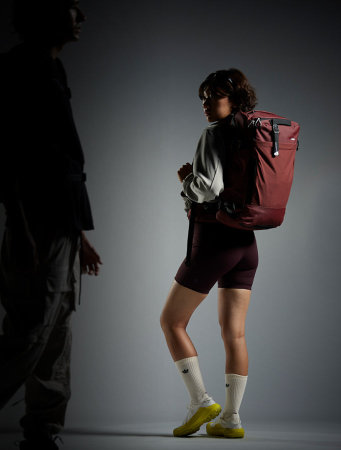 Woman in moody, dark studio background, wearing Garnet GlobeRider35
