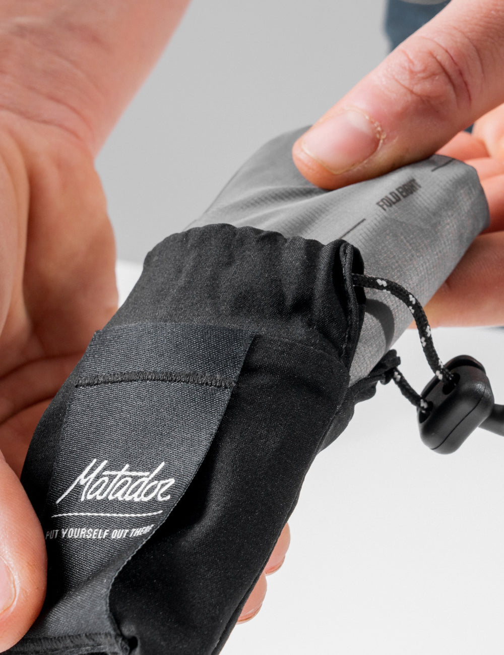 hands pulling pocket blanket from storage bag