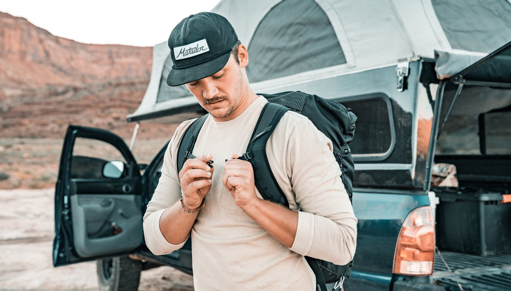 Man next to truck in desert canyon, buckling sternum strap of SEG45