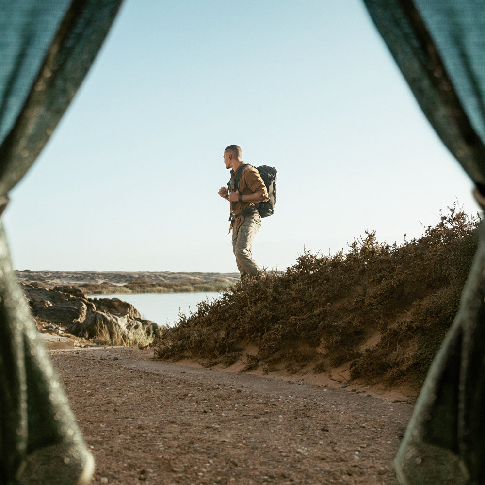 Man wearing backpack in desert landscape