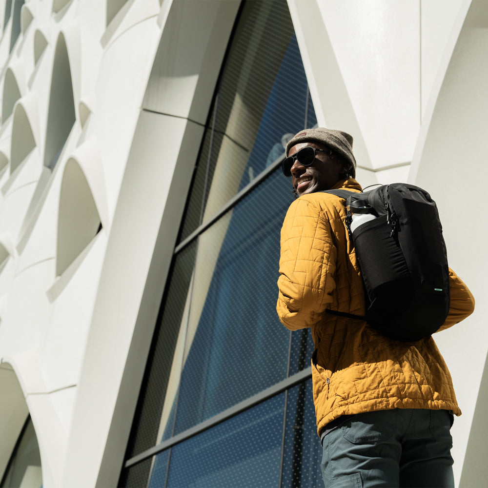 man in yellow jacket wearing black backpack