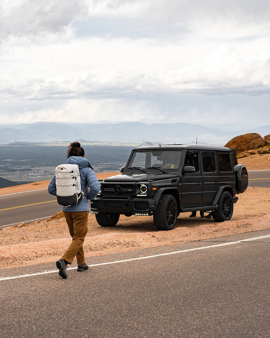 person traveling across the road wearing a white backpack